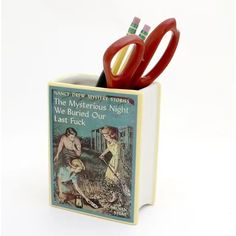 a pair of red scissors sitting on top of a book with an image of two children