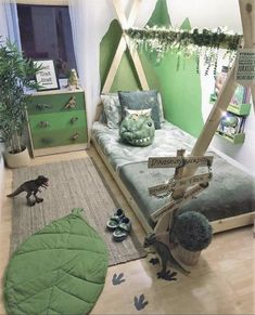 a bedroom decorated in green and white with dinosaur toys on the floor, including a bed