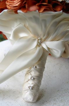 the bouquet is adorned with satin ribbons and pearls