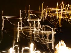 blurry photograph of lines and shapes in the night sky, with light streaks on them