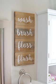 a wooden sign that says wash brush floss flush on the wall above a sink