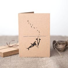 there is a card with a drawing of two dolphins on it and the words happy birthday written in black ink