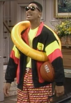 a man holding a basketball and an inflatable banana