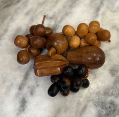 an assortment of nuts and black olives on a marble surface