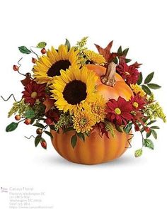 a pumpkin filled with sunflowers and other flowers