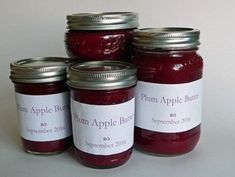 four jars of plum apple butter sitting next to each other