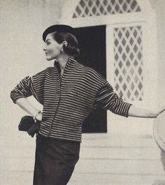 an old photo of a woman standing in front of a building with her hands on her hips