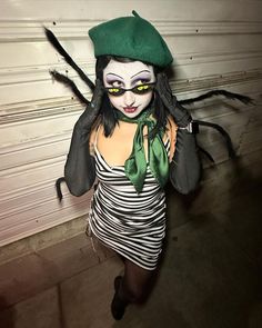 a woman dressed up as a beetle with green eyes