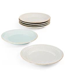 four plates stacked on top of each other in different colors and sizes, all with gold rims