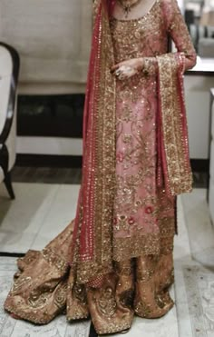 a woman in a pink and gold wedding outfit