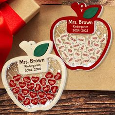 an apple shaped ornament is next to a gift box with a red ribbon