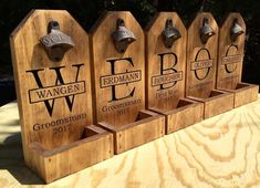 four wooden signs with bells on them are sitting on a piece of wood that has been carved into it