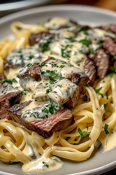 a white plate topped with pasta and steak