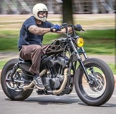 a man riding on the back of a motorcycle down a street