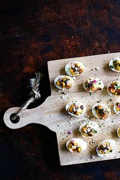 small deviled eggs with sprinkles on a cutting board