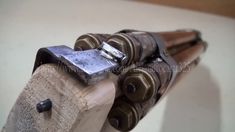 a close up of a metal object on top of a wooden block with nails sticking out of it