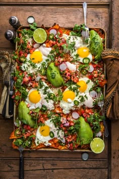 an overhead view of a square dish with eggs, lettuce and other vegetables