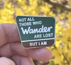 a green and white sign that says not all those who wander are lost but i am