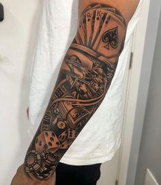 a man with a tattoo on his arm has a clock and playing cards in it