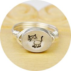 Stick Figure Cat Ring-Sterling Silver Filled Wire Wrapped Ring with Hand Stamped Pewter Bead- Any Size 4, 5, 6, 7, 8, 9, 10, 11, 12, 13, 14 by SimplyCharmed21 on Etsy https://www.etsy.com/listing/207972095/stick-figure-cat-ring-sterling-silver Unique Hand Stamped Round Jewelry, Adjustable Hand Stamped Round Jewelry, Adjustable Round Hand Stamped Jewelry, Adjustable Round Etched Jewelry, Adjustable Stamped 925 Jewelry For Birthday, Cat Rings Jewelry, Cat Things, Cat Bead, Wire Wrapped Ring