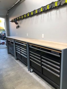 a garage with lots of workbenches and tools hanging on the wall in front of it