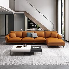 a modern living room with an orange couch and coffee table in front of the stairs