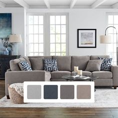 a living room with gray couches and blue accents on the walls, along with white rugs