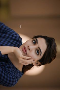 a woman is posing for the camera with her hand on her face