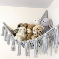 stuffed animals are sitting in a hammock with tassels