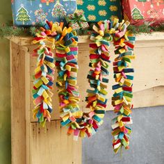 colorful ribbons hanging from a mantle in front of presents