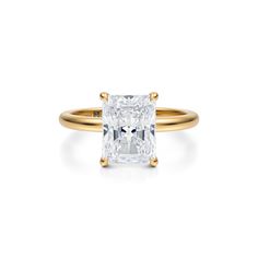 an engagement ring with a princess cut diamond in the center and two tone gold band