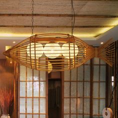 a bamboo chandelier hanging from the ceiling in a room with large windows and doors