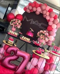 a table topped with pink and red balloons