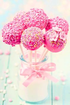 pink cake pops with sprinkles in a glass jar