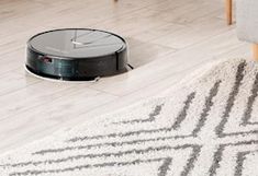 a roomba is on the floor in front of a couch