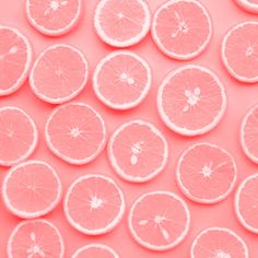 pink grapefruit slices arranged in a pattern on a light pink background stock photo