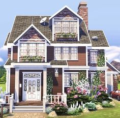 a large brown house with lots of windows and flowers on the front porch, along with a white picket fence