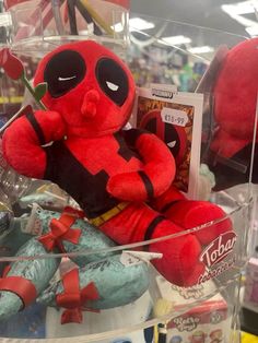 a deadpool stuffed animal is in a display case with other toys on the shelf