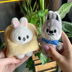 two small stuffed animals are being held in their hands