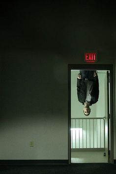 a person hanging upside down in an exit way