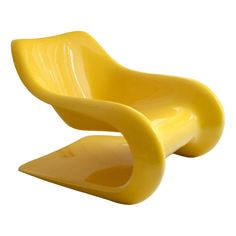 a yellow chair that is shaped like an egg shell and sits in front of a white background