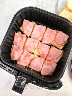 ham is cooked in an air fryer and ready to be served with bread on the side