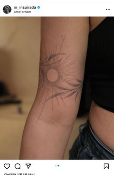 a woman's arm with a sun tattoo on the left side of her arm