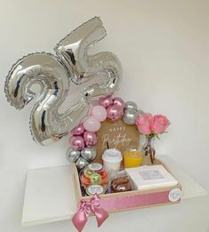 a birthday gift box with balloons, confetti and other items in the shape of numbers