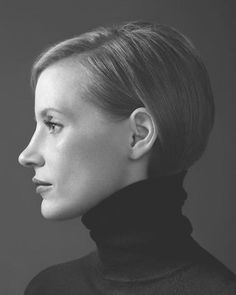 a black and white photo of a woman with short hair wearing a turtle neck sweater