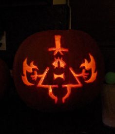 a pumpkin carved to look like a tree with arrows and crosses on it, lit up at night