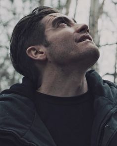 a man standing in the woods looking up into the sky with his eyes closed and head tilted to the side