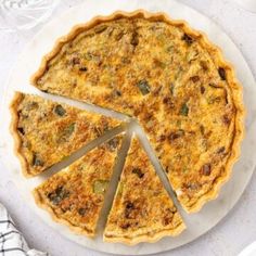 a quiche on a plate with slices cut out