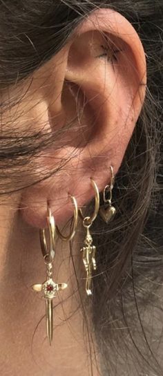 a close up of a person's ear with two earrings on top of it