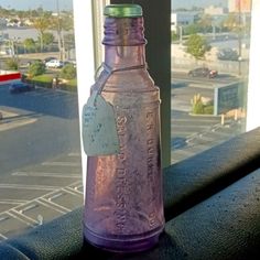 a purple bottle sitting on top of a window sill